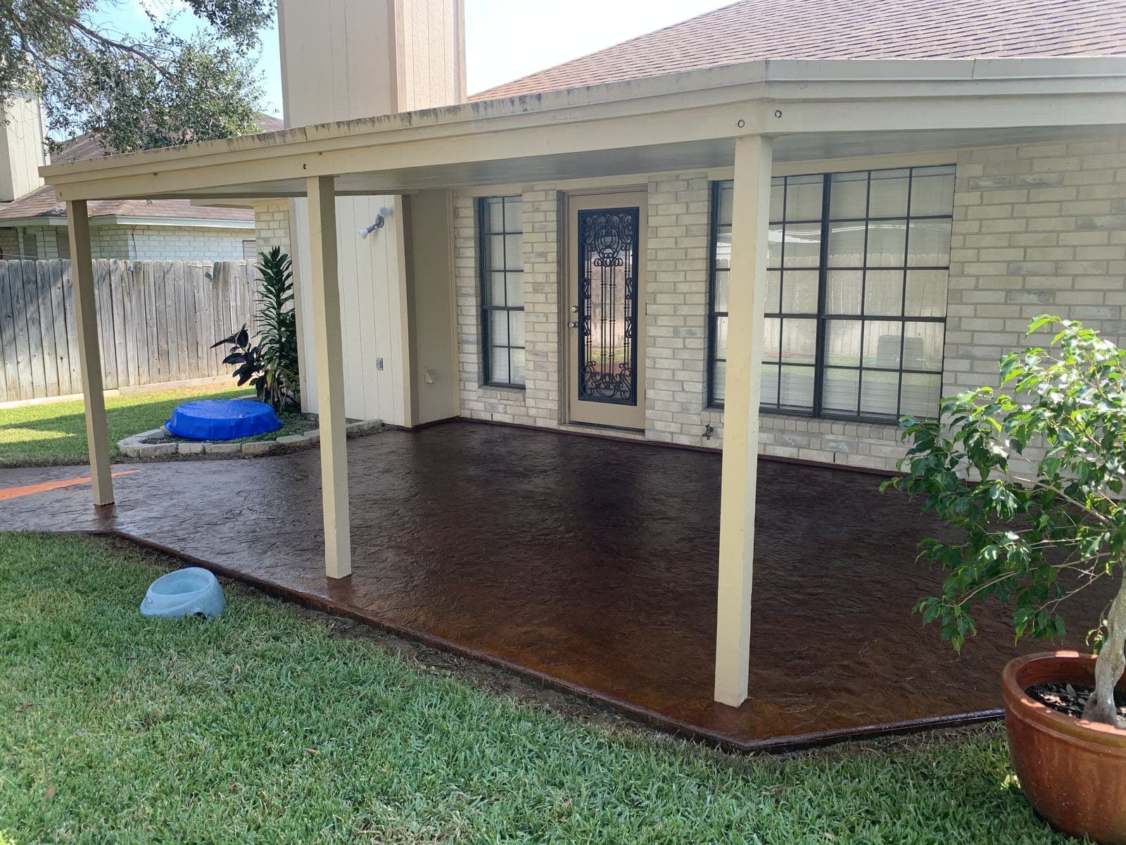 Covered back porch with a dark acid-stained concrete floor