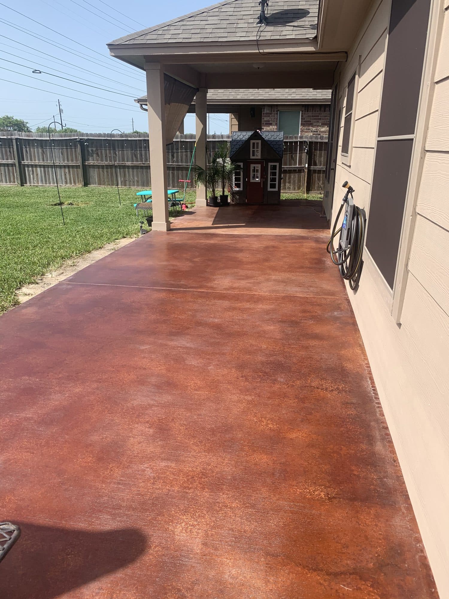 Reddish-brown acid-stained concrete wrapping a covered porch