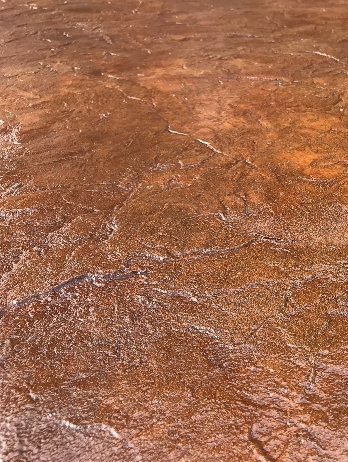 Close-up of rust-colored acid stain texture on concrete