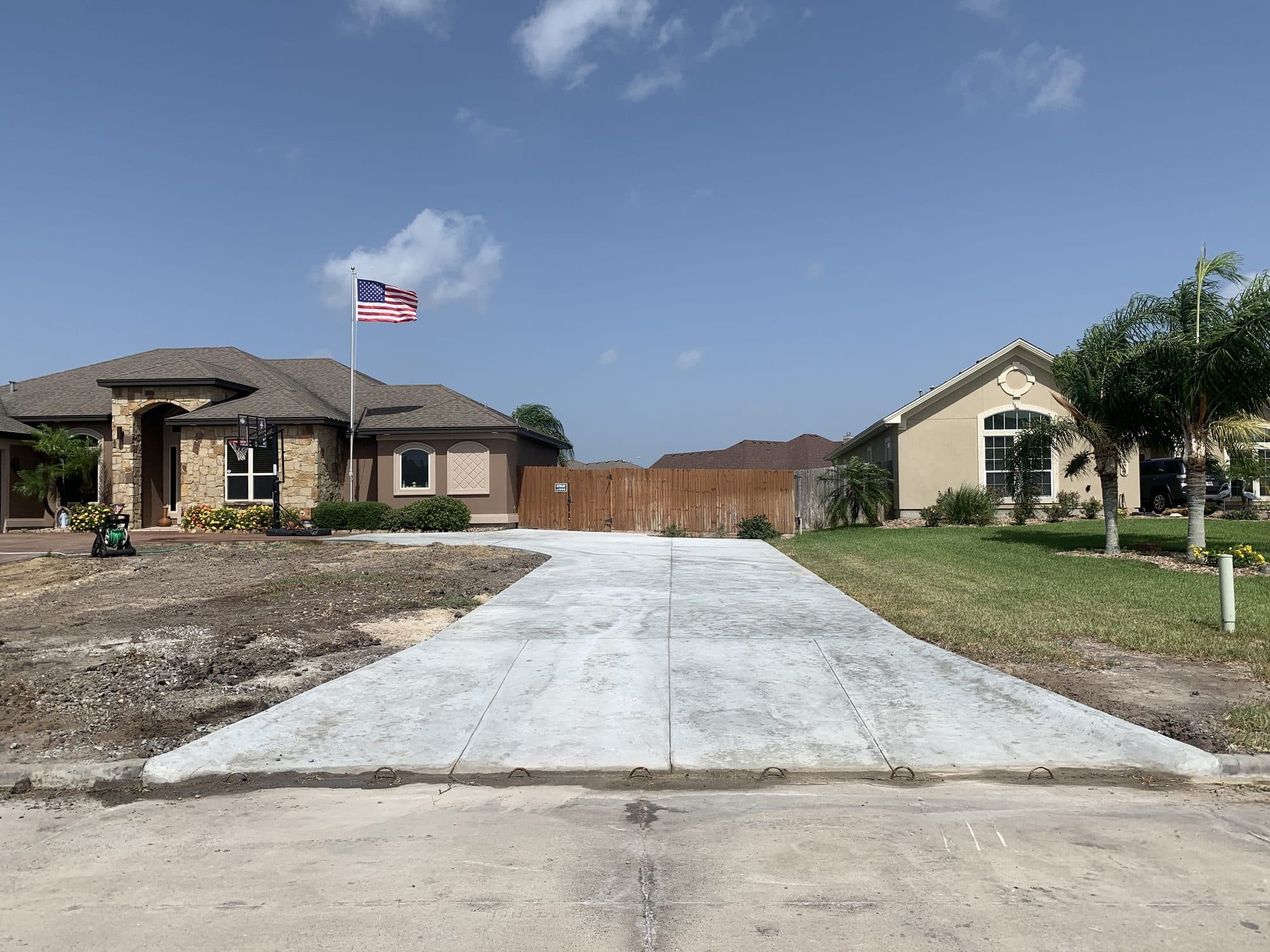 Wide broom-finished concrete driveway at a newly built home