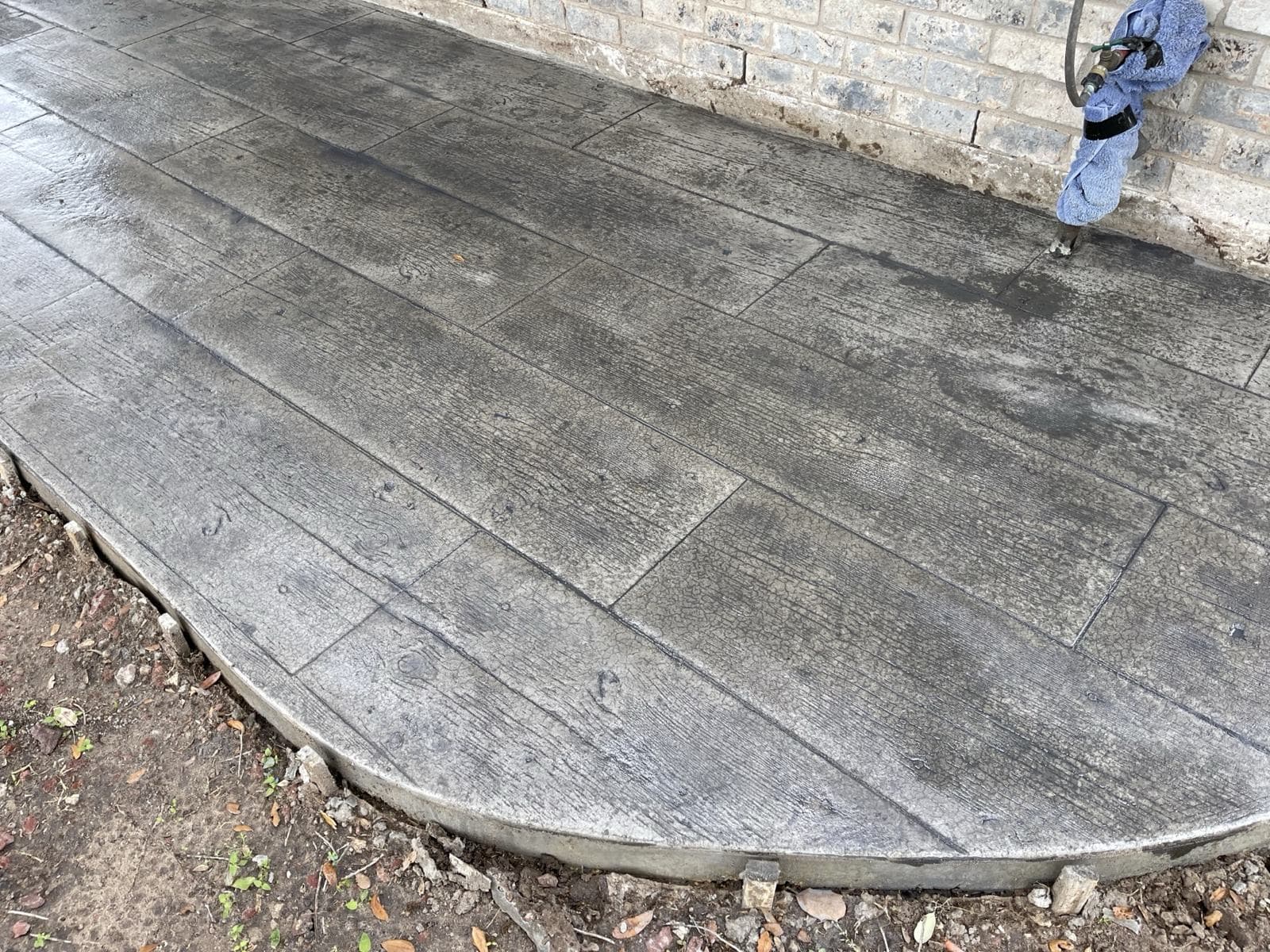 Curved stamped concrete patio in a gray ashlar slate pattern