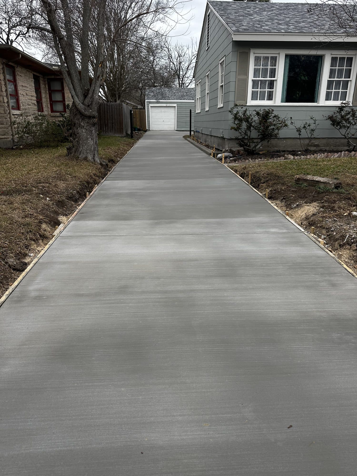 Broom-finished concrete walkway leading to a front entry