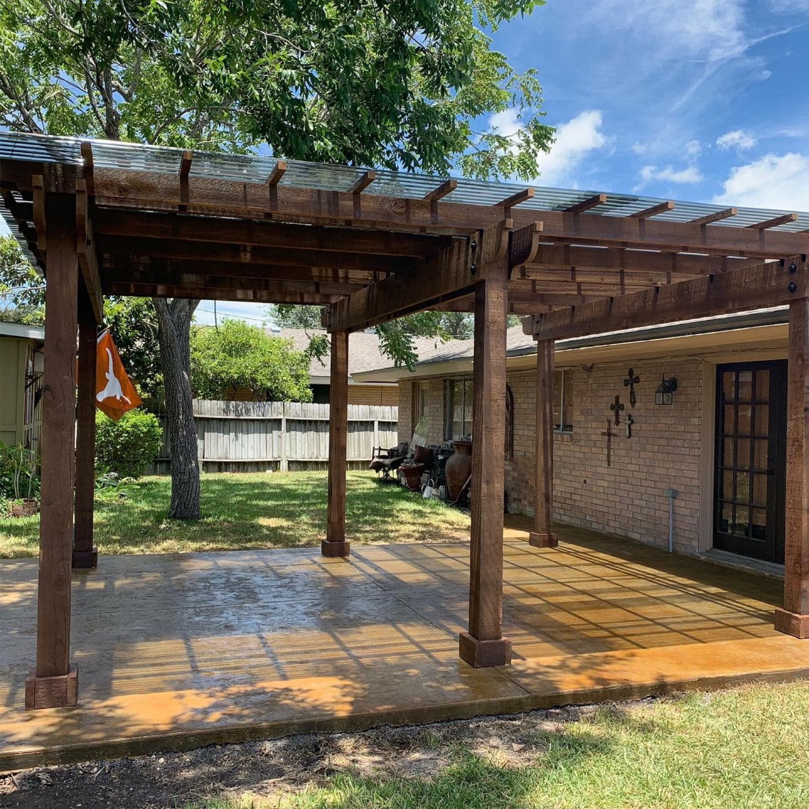 Cedar pergola over a stamped concrete patio with string lights