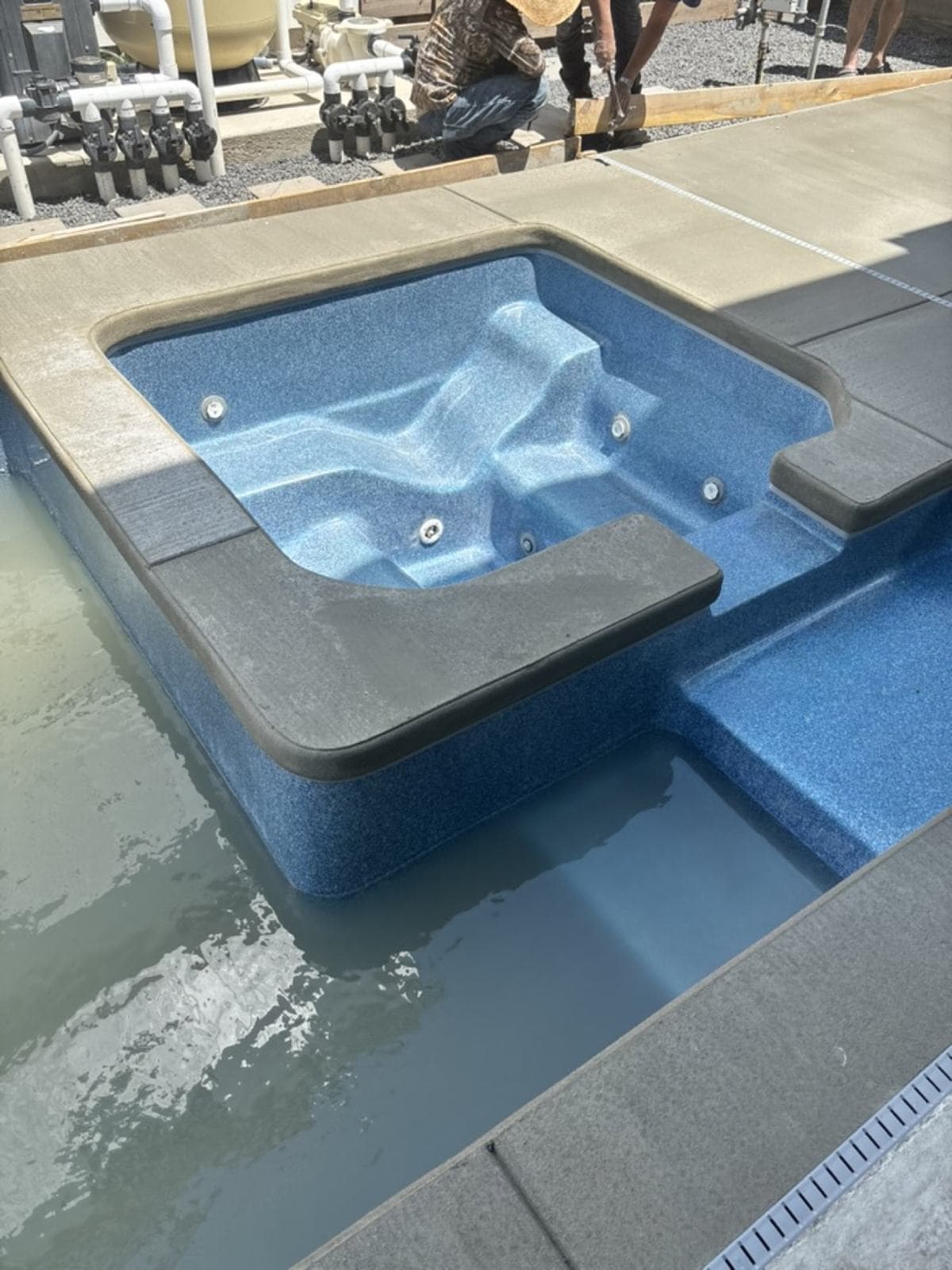 Close-up of a pool spa spillway and the surrounding deck