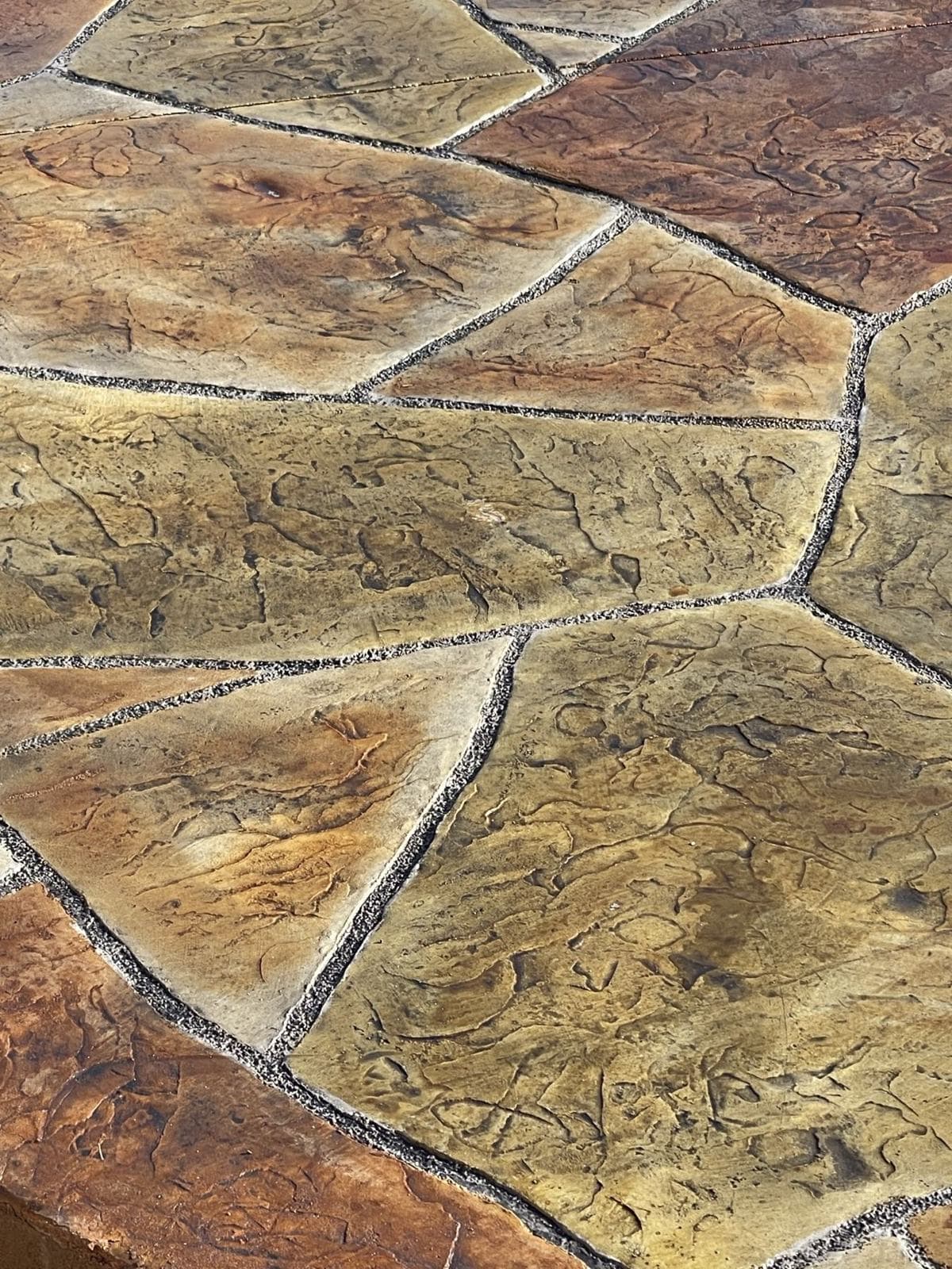 Close-up of stamped flagstone concrete in gold and rust tones