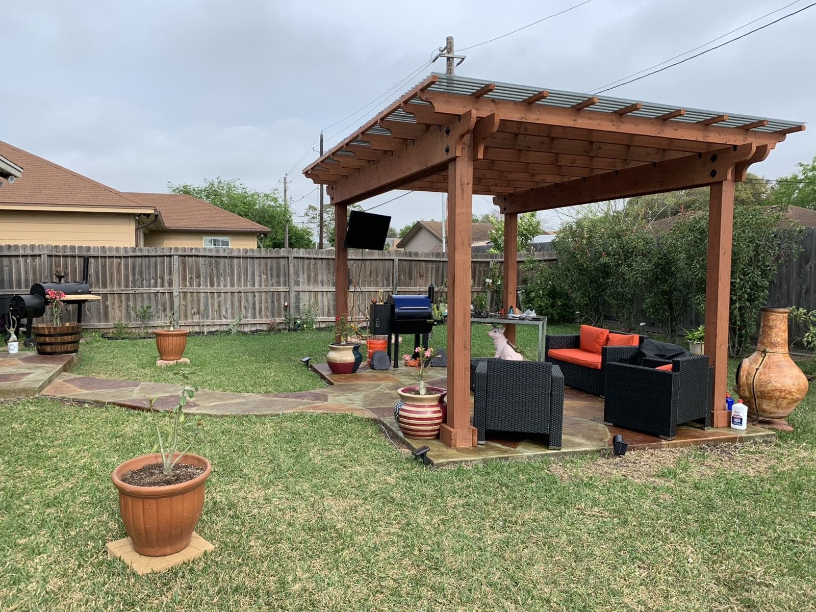 Pergola and stamped patio with outdoor seating and a grill
