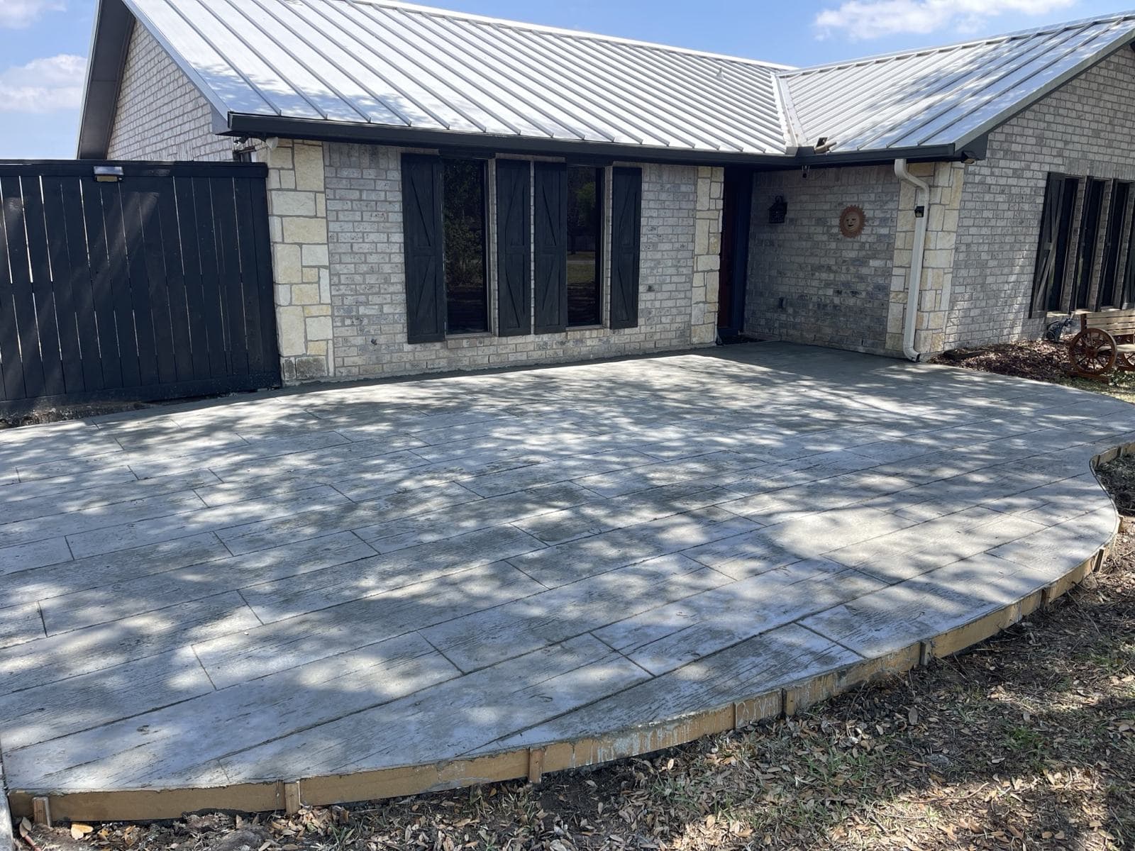 Wide stamped concrete patio behind a single-story home