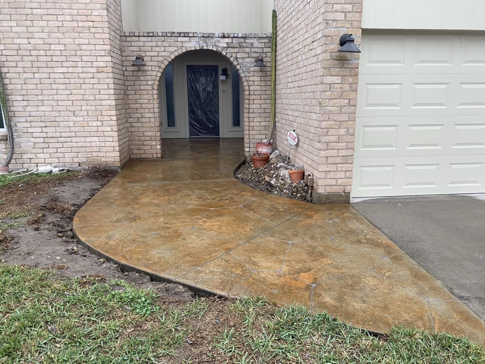 Acid-stained concrete entry walkway curving to a front door
